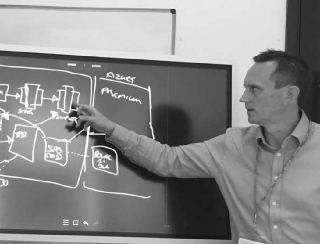 a man drawing a data architecture framework on a whiteboard